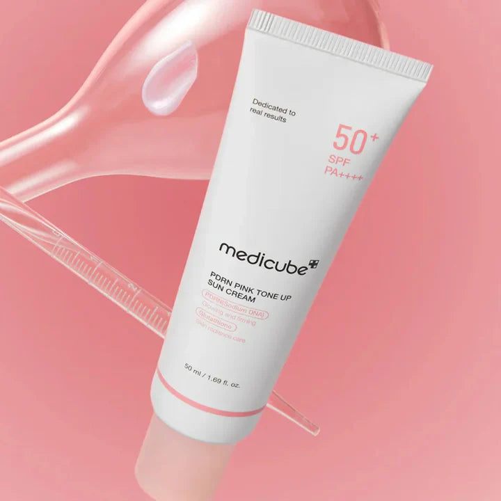 Medicube+ PDRN Pink Tone Up Sun Cream on pink background with cream swirl