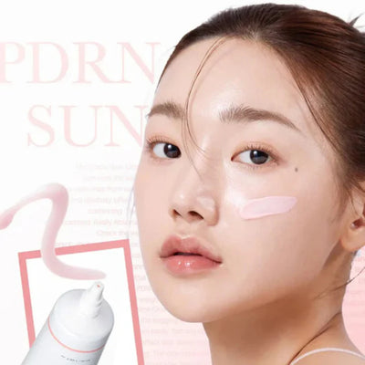 Woman applying Medicube+ PDRN Pink Tone Up Sun Cream - lifestyle
